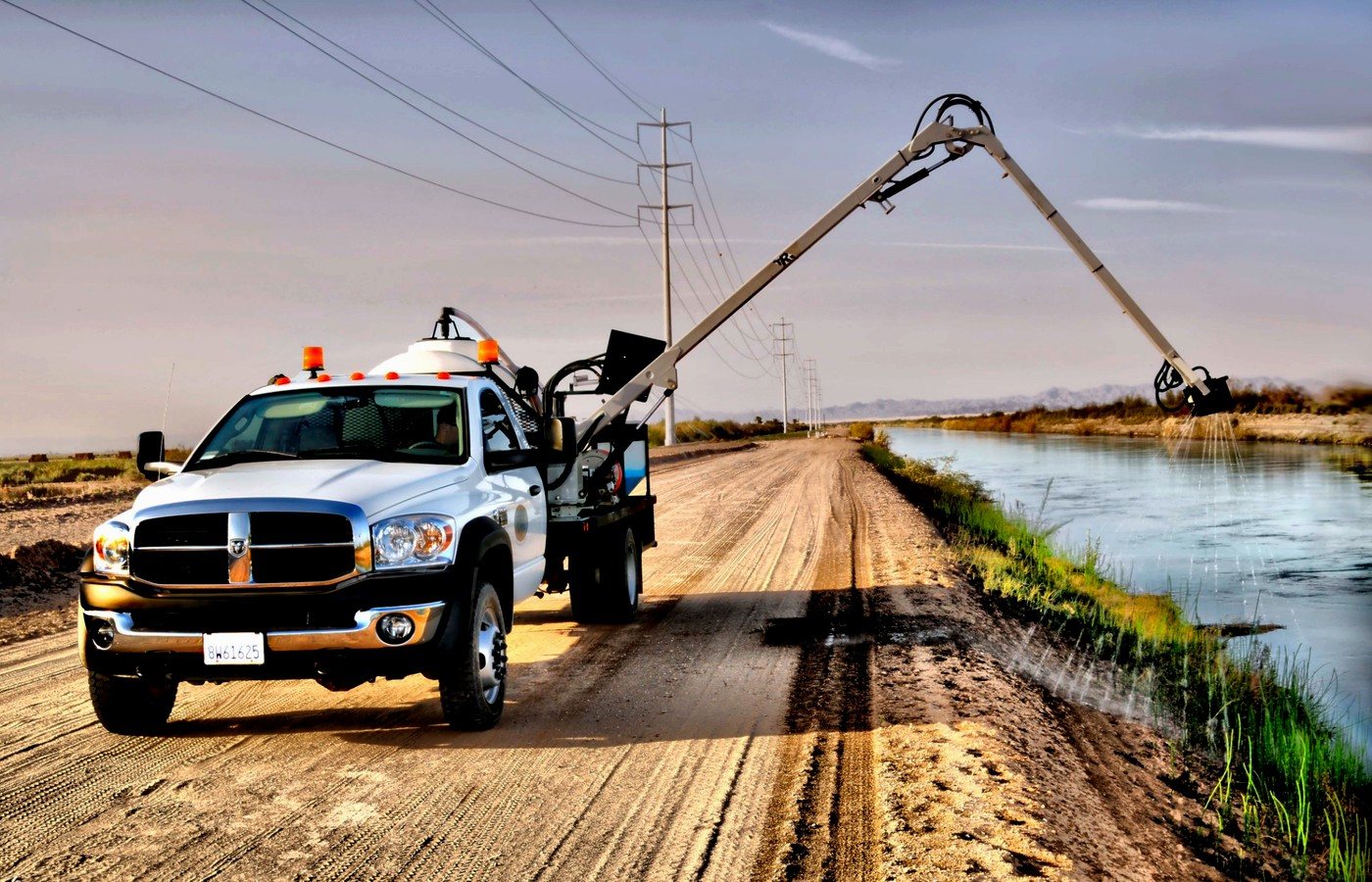Specialized spray truck operating along a canal